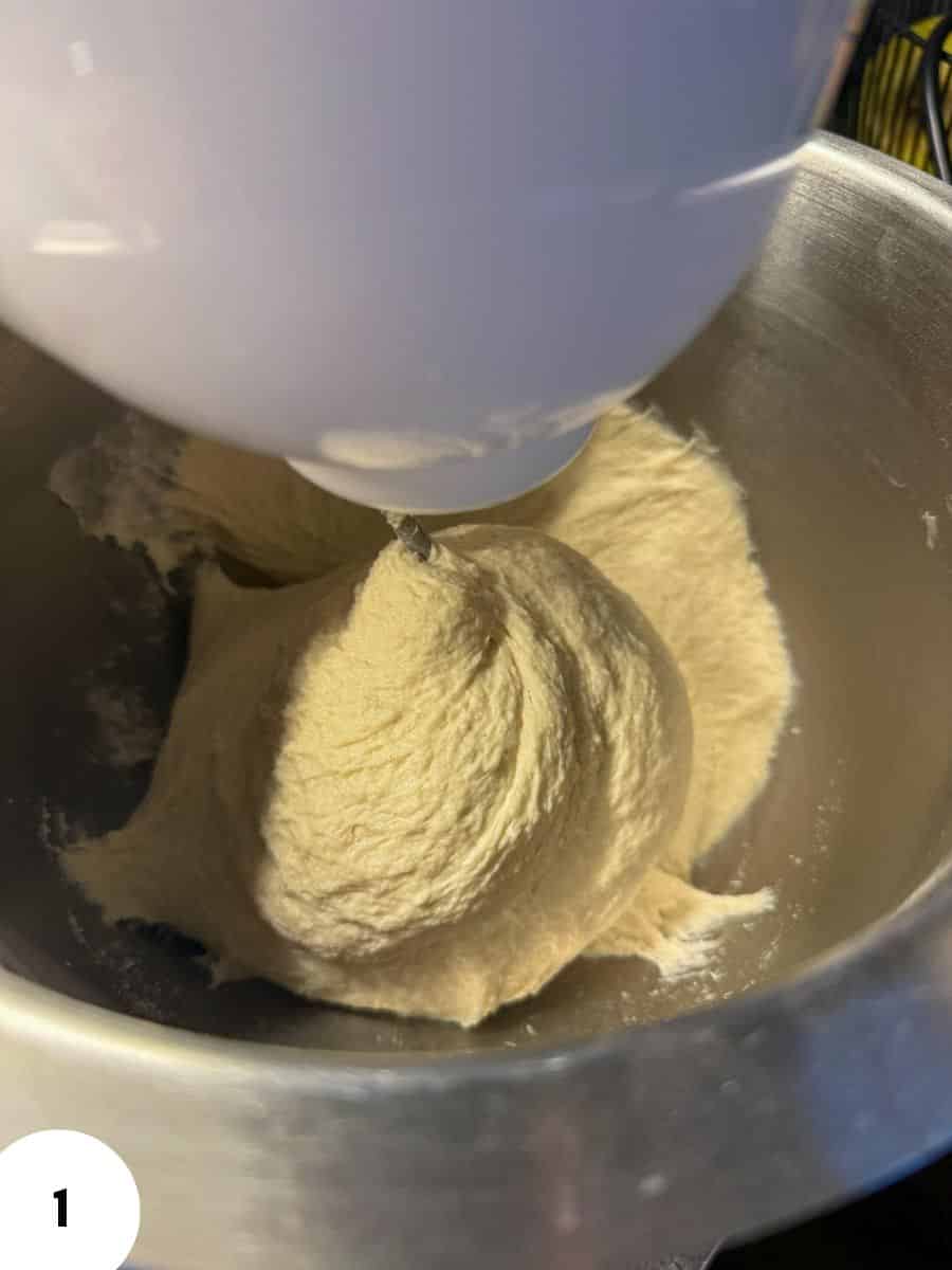 Creme-colored dough being kneaded in a mixer bowl with a white beater.