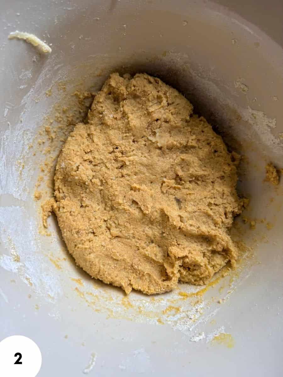 Dough for bread or pastry being stretched and folded in a mixing bowl.