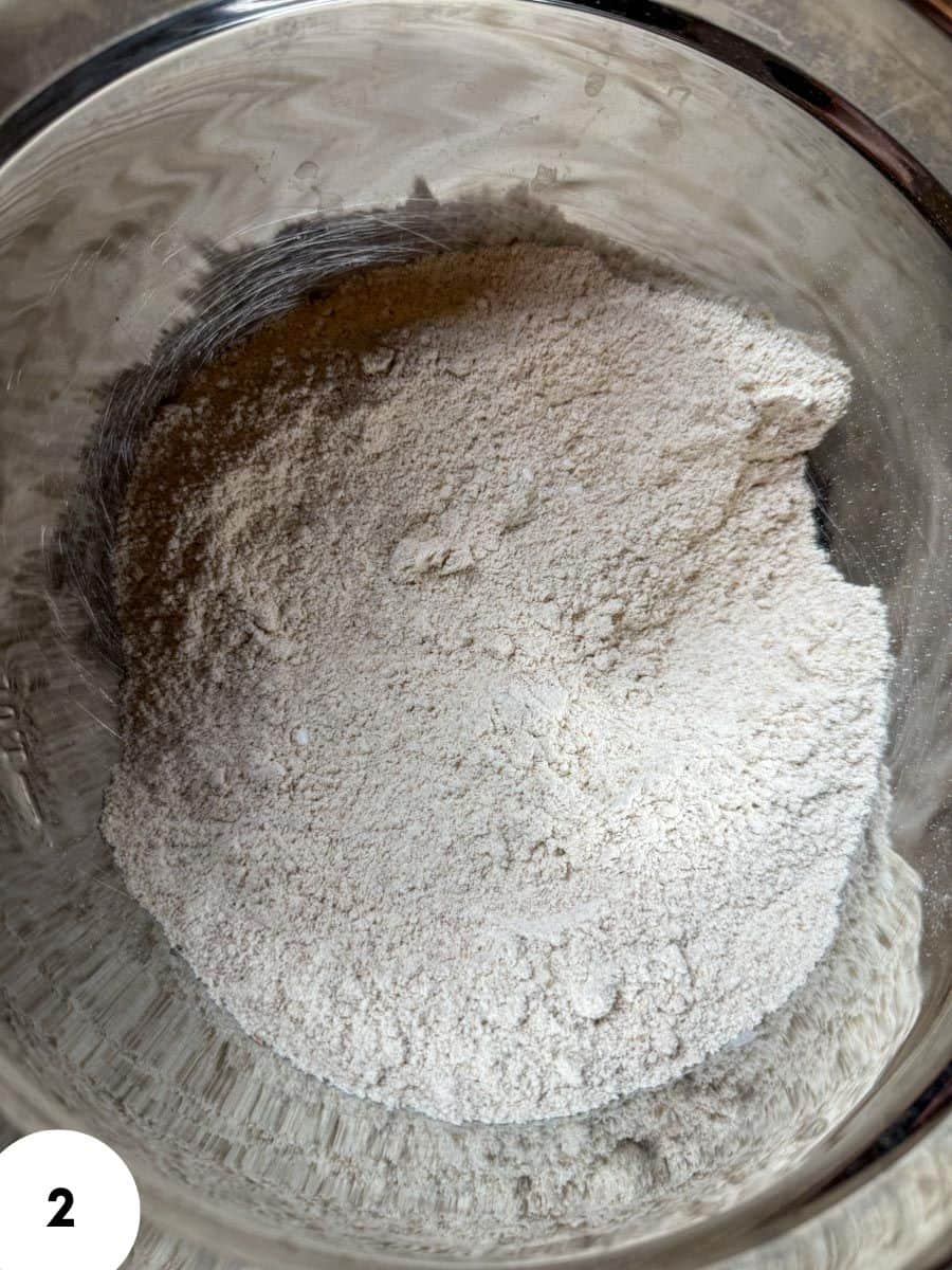 Flour mixture in a glass bowl for bread dough preparation.