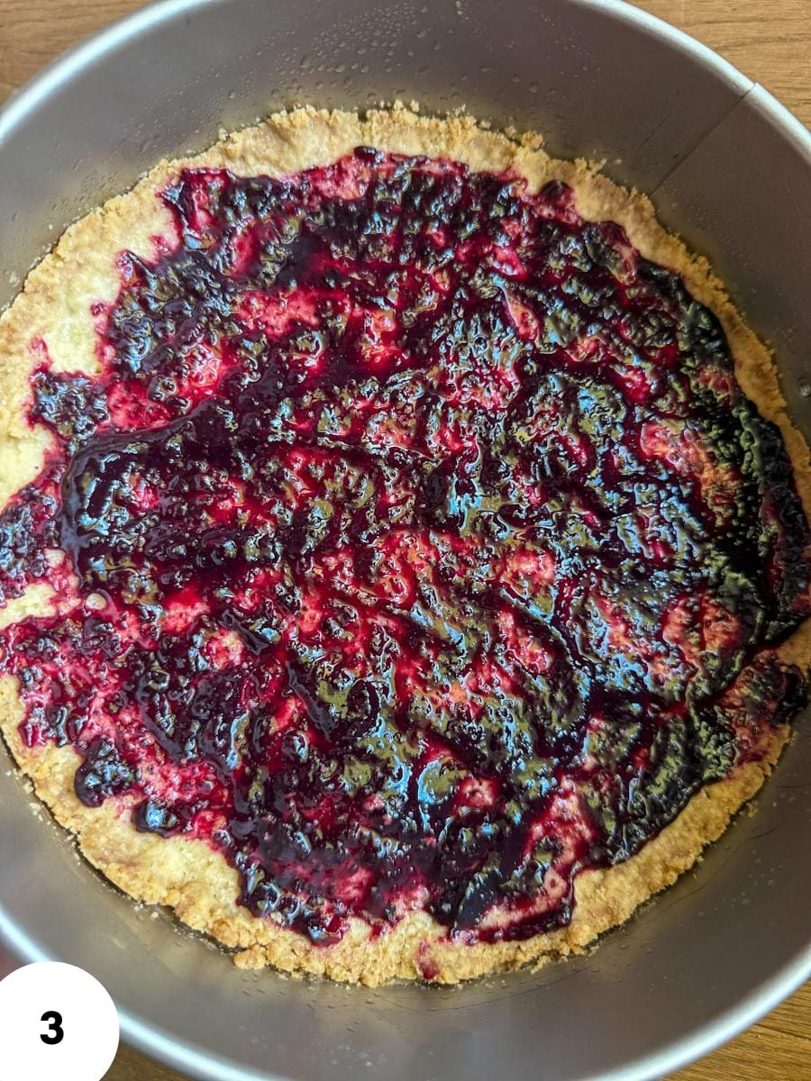 Berry tart dough with fruit topping in a baking pan.