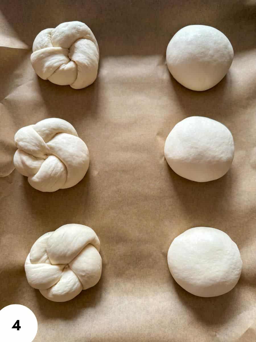 Six braided and round dough balls on parchment for baking.