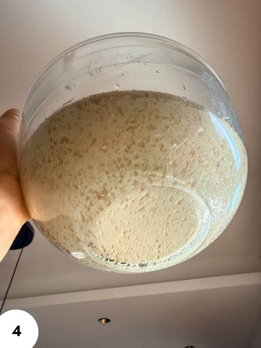 Fermenting dough in a glass bowl for bread making.
