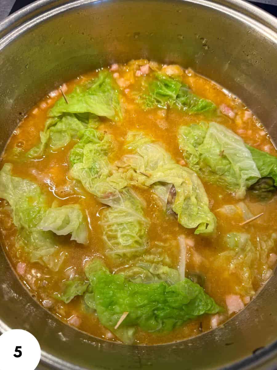 Soup with leafy lettuce in a pot.