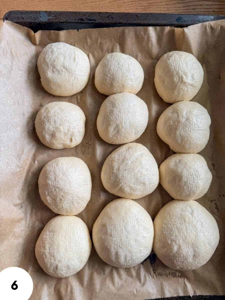 Raw dough balls prepared for baking on parchment paper.