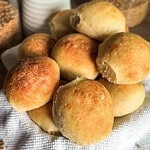 Golden-brown bread rolls on a cloth, freshly baked and inviting.