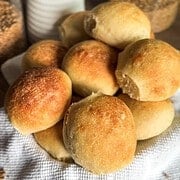 Golden-brown bread rolls on a cloth, freshly baked and inviting.