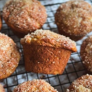 Close-up of homemade muffins with sugar topping on a cooling rack.