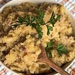 Creamy mashed potatoes garnished with parsley and herbs.