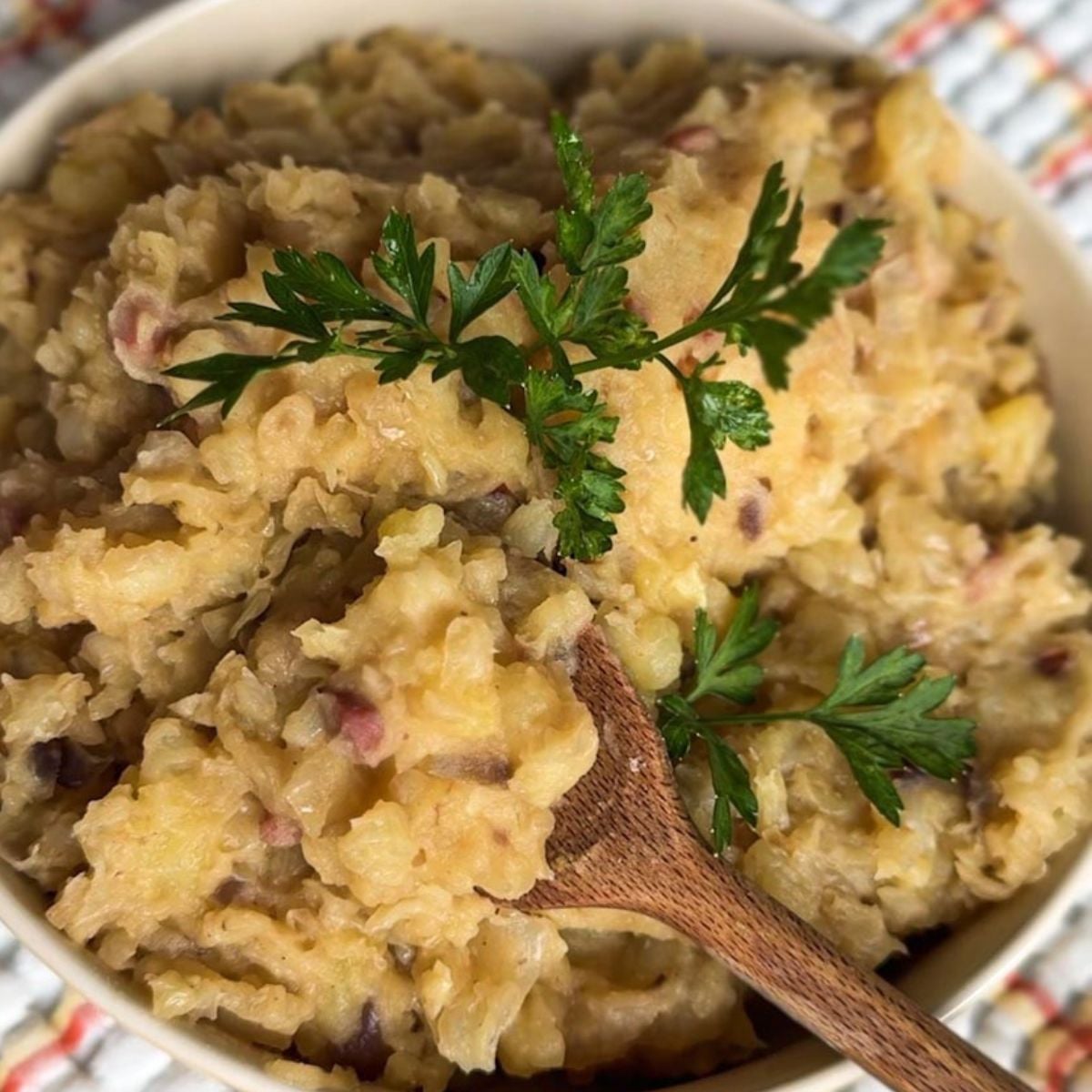 Creamy mashed potatoes garnished with parsley and herbs.