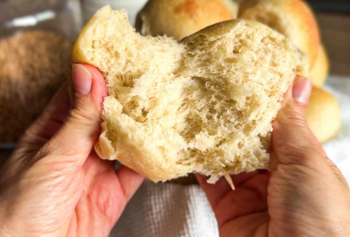 Close-up of hand tearing soft, fluffy bread for optimal SEO.