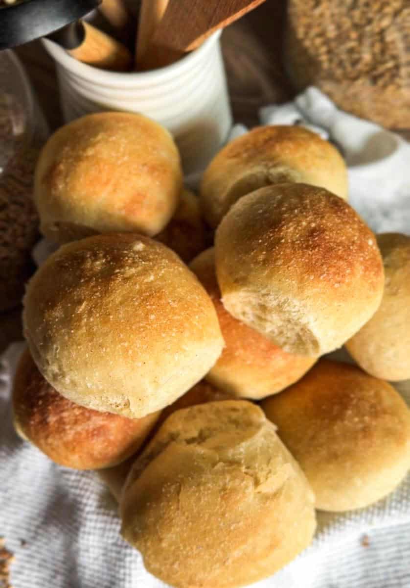 Close-up of golden, freshly baked bread rolls on a white cloth.