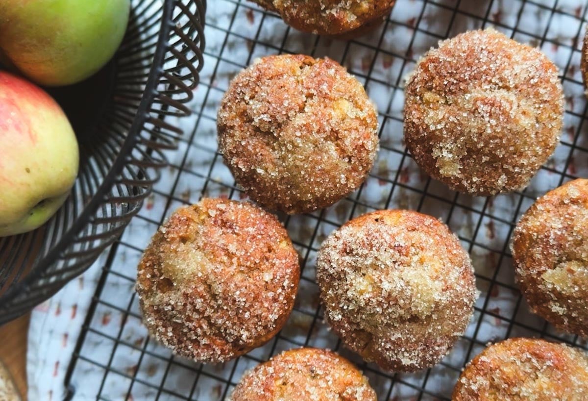 Apple cinnamon muffins with sugar topping on a cooling rack.